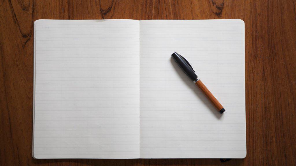 pen on an open and empty notebook