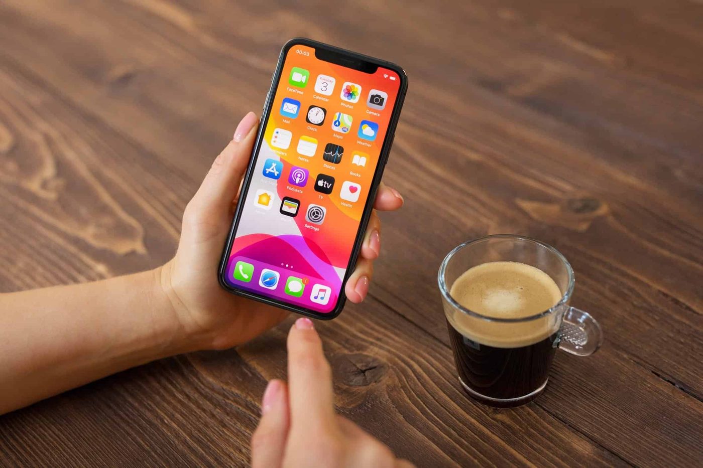 Woman holding a smartphone while drinking coffee