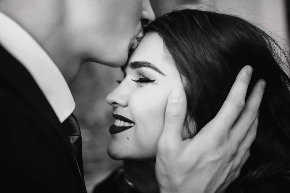 man kiss woman forhead