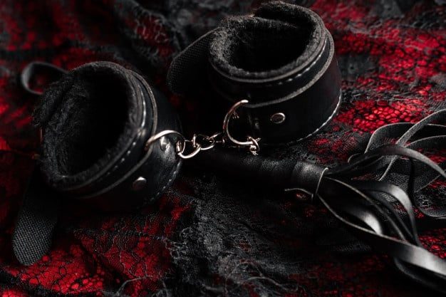 whip, leather hand cuffs and lace underwear