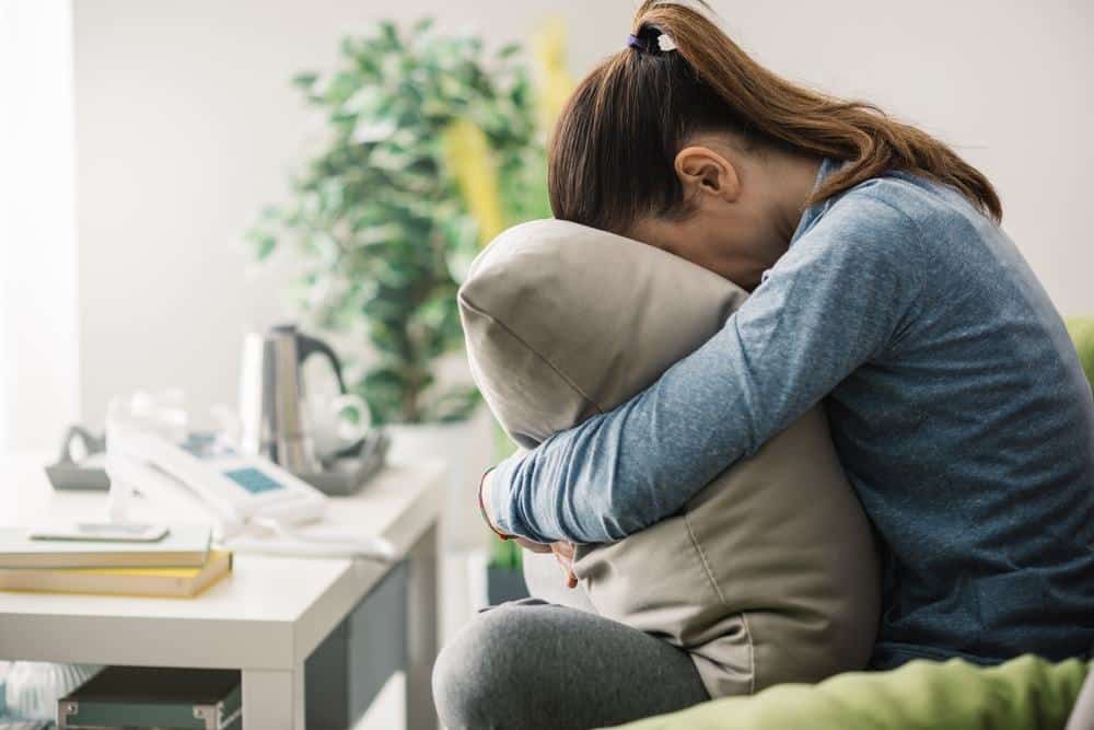 woman sad hugging pillow