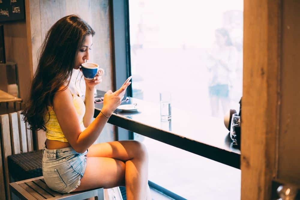 woman drinking coffee and texting
