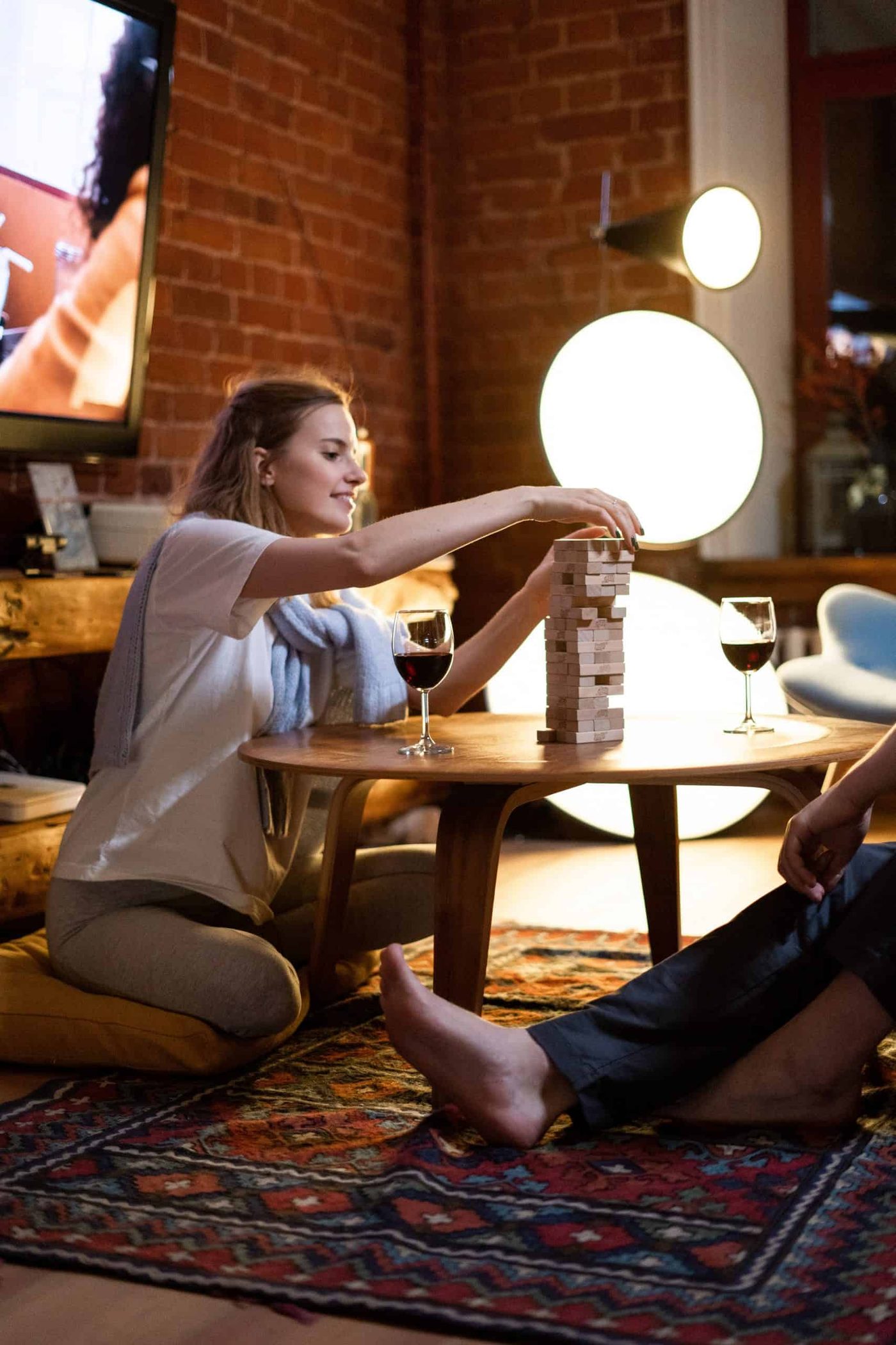 couple having a romantic evening with wine and candles playing jenga