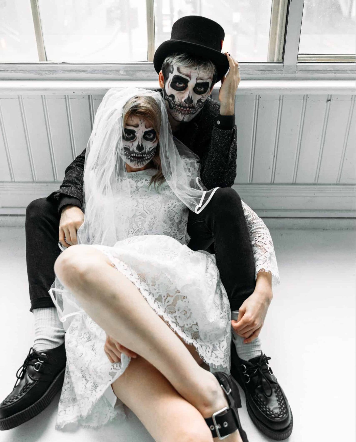 couple wearing goth wedding clothes and face skeleton make up