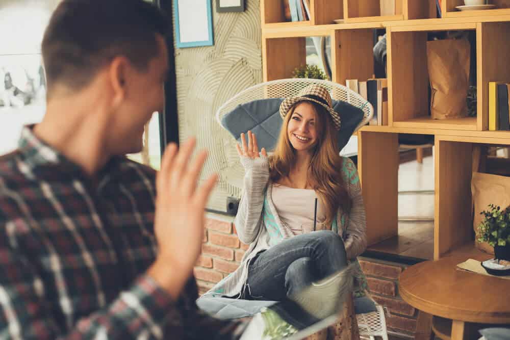 man saying hello to a woman in a cafe