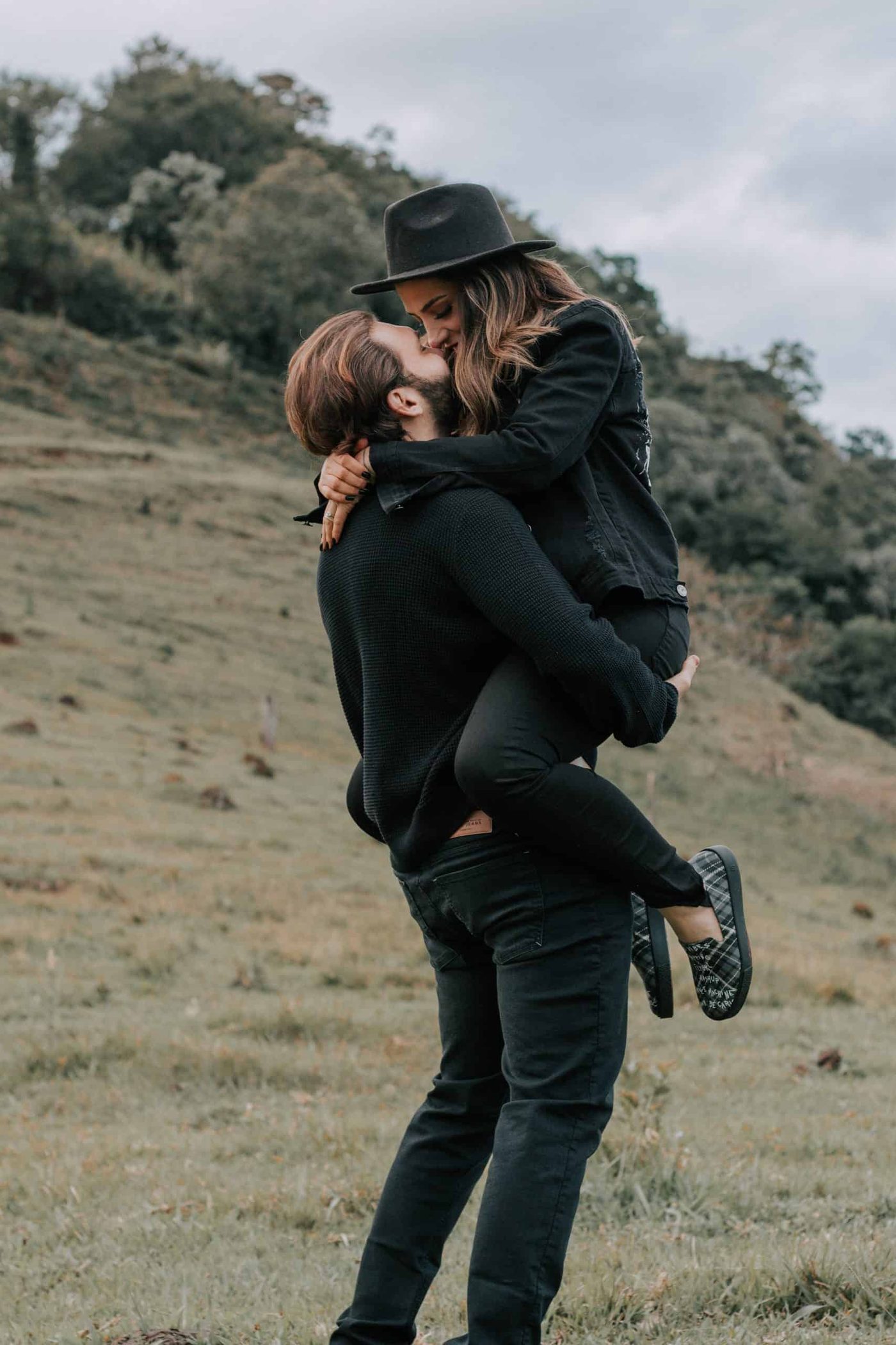 man holding girldfriend in the air, embracing each other and kissing