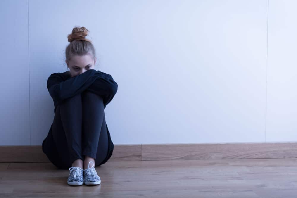 sad woman sitting alone on the floor