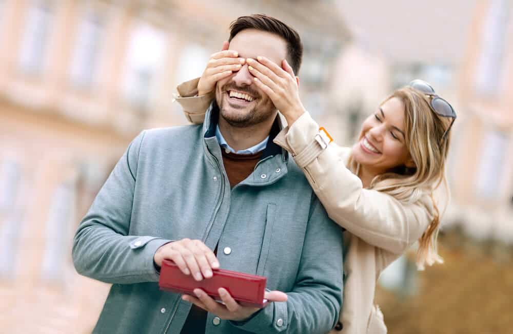 woman giving her husband a birthday gift
