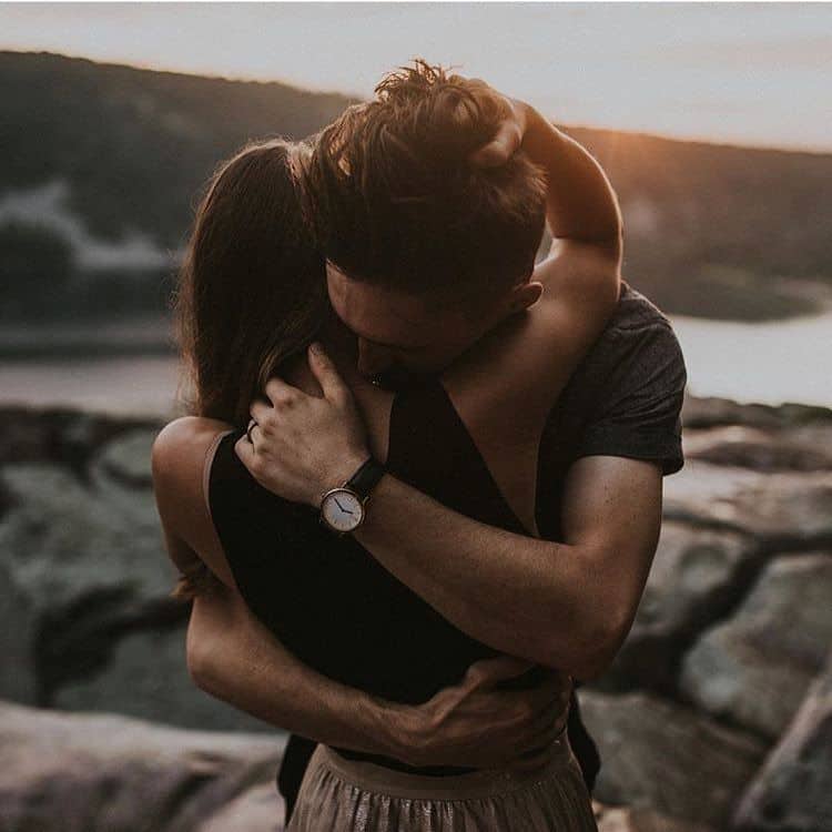 couple on the beach reuniting in warm and strong embrace