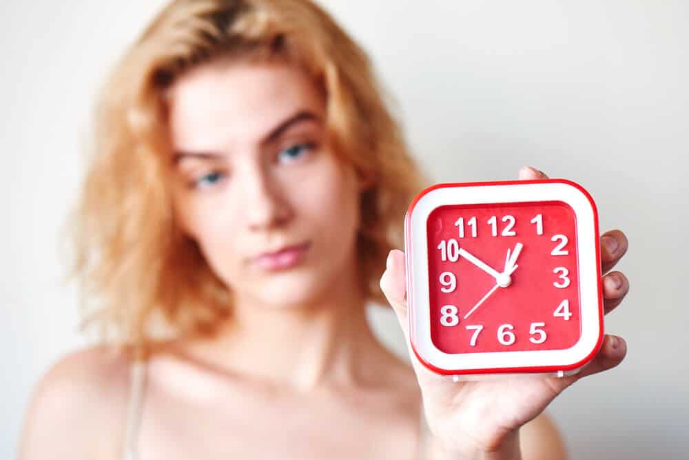 woman holding a clock