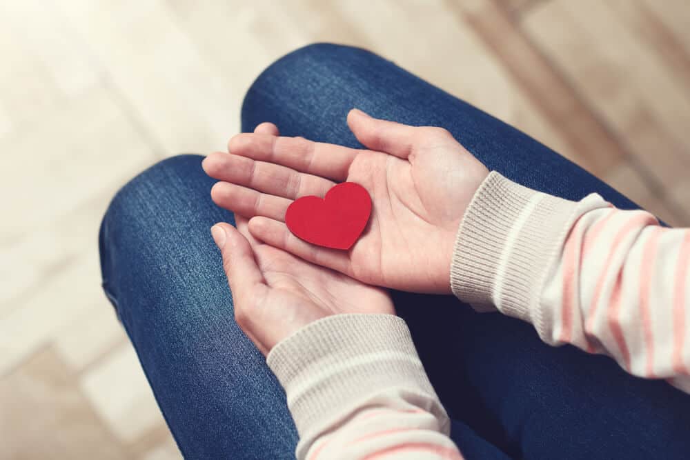 woman holding a paper heart in her hands