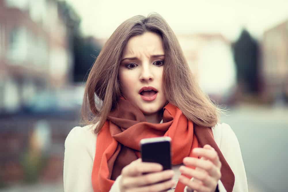 woman shocked looking at the phone
