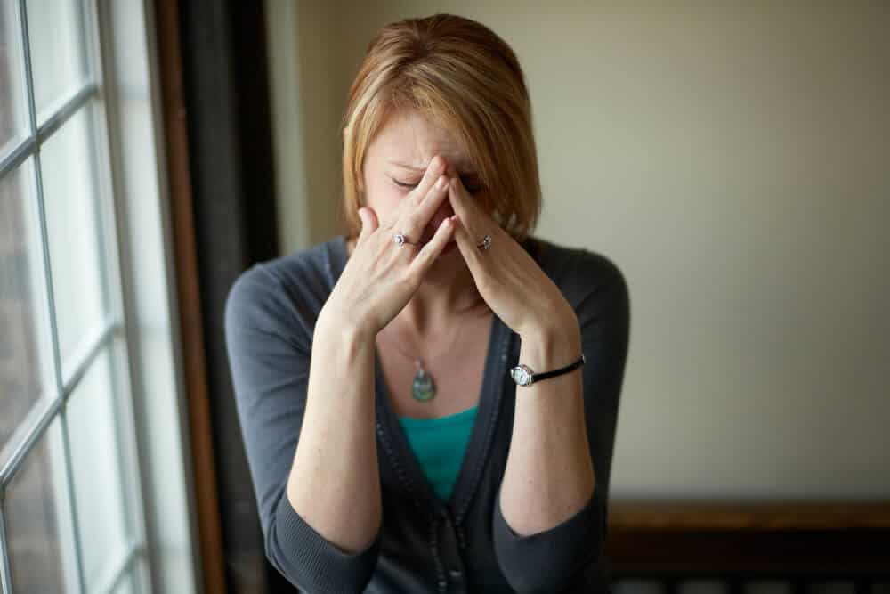 Woman cries hiding her face
