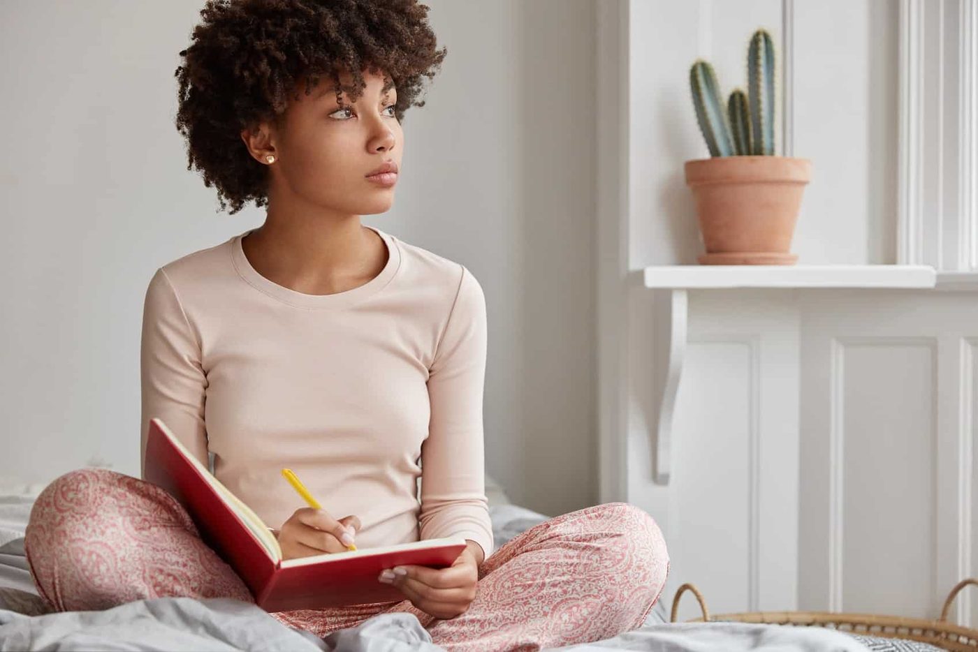 woman sit writing bed