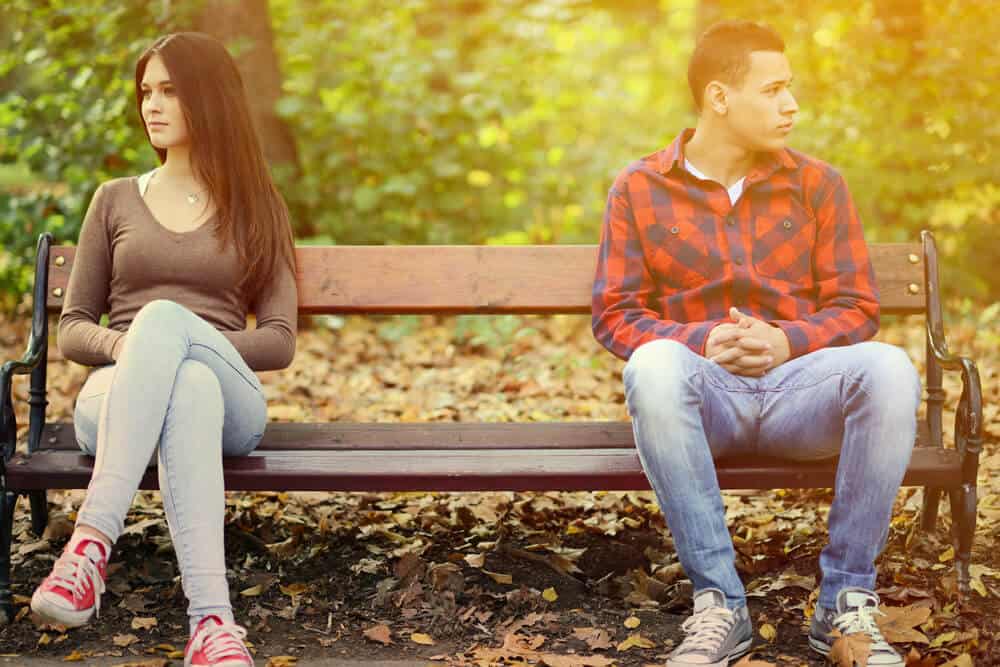 couple on a bench ignoring each other