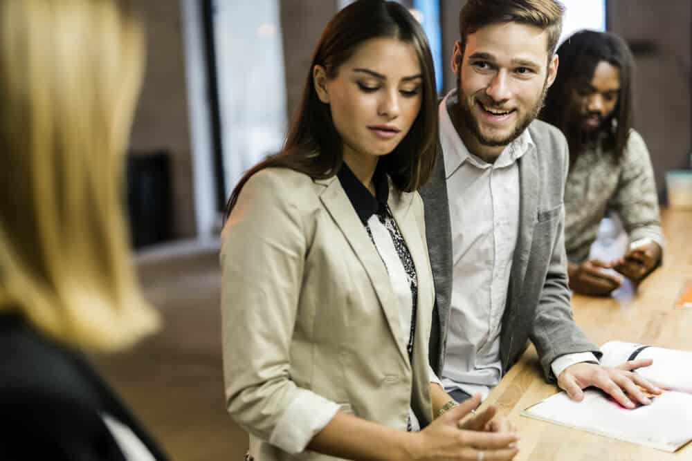 man smiles in office to a woman