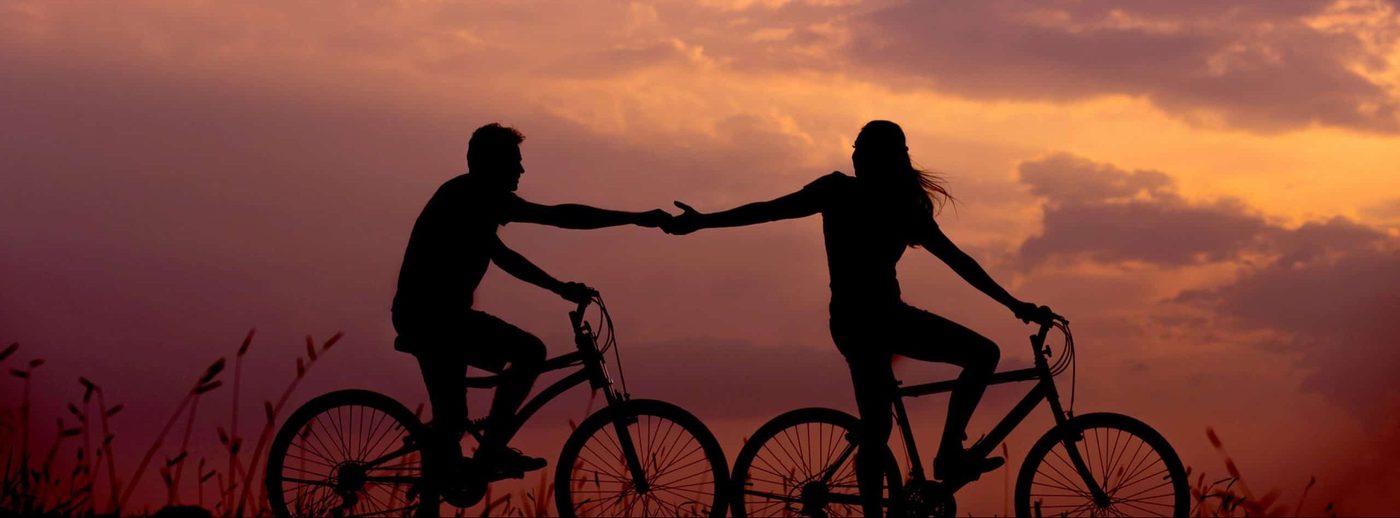 Woman holding man's hand on bicycle