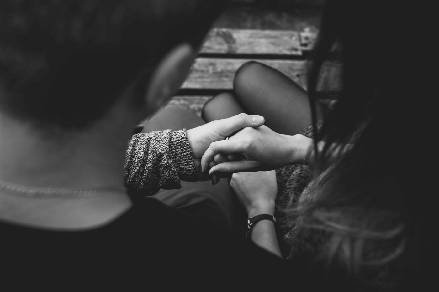 Couple sitting on a bench, man holding his girlfriends hand