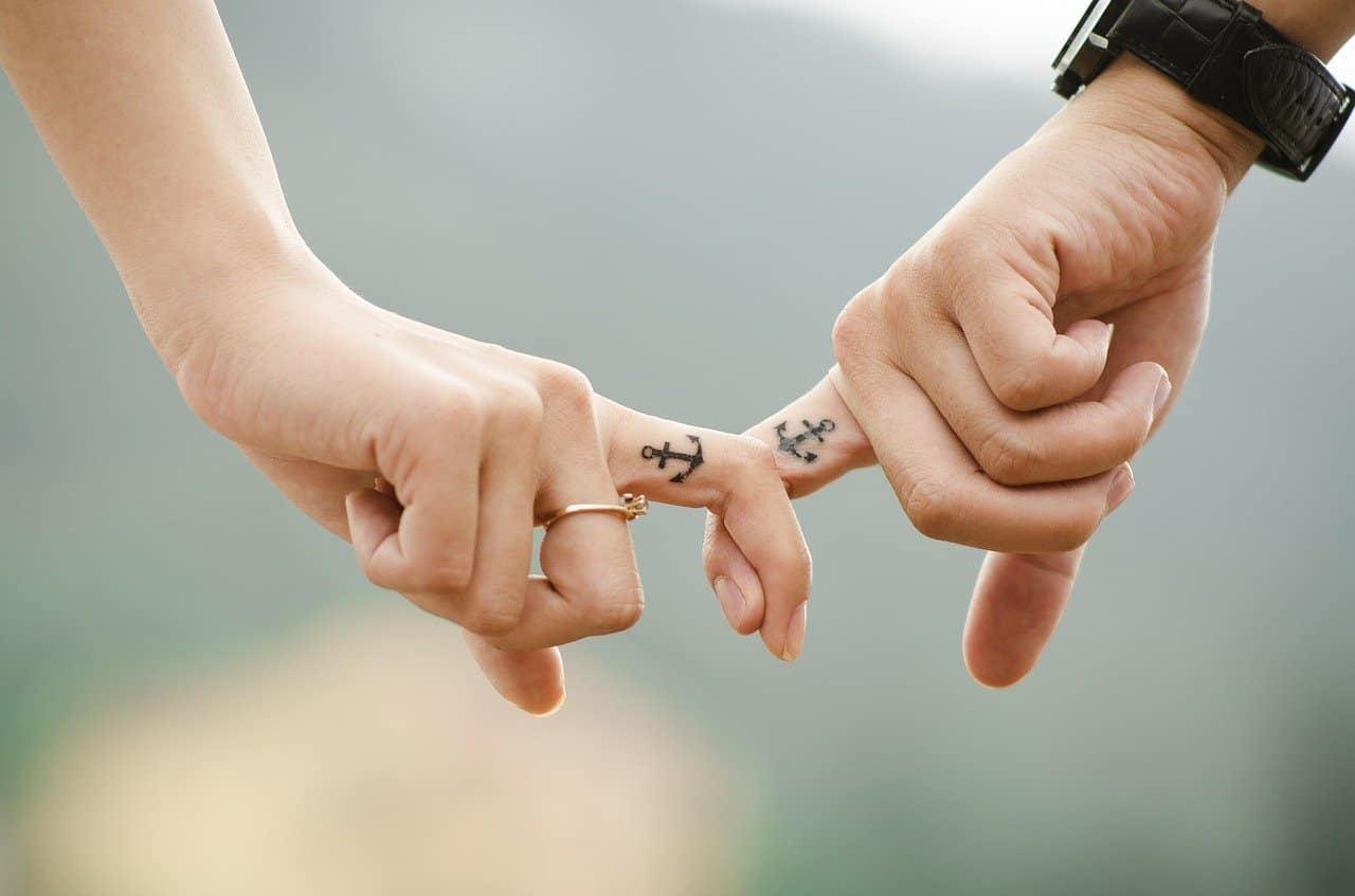 couple crossing index fingers together and barely holding on