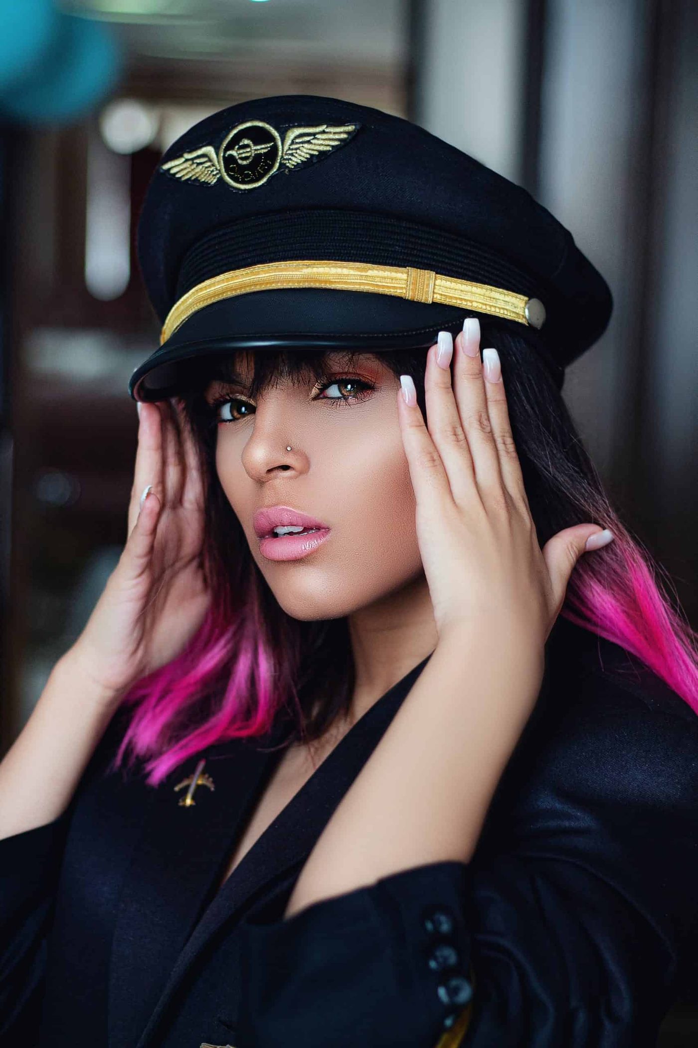 Woman in a flight captain's hat looking directly at the camera