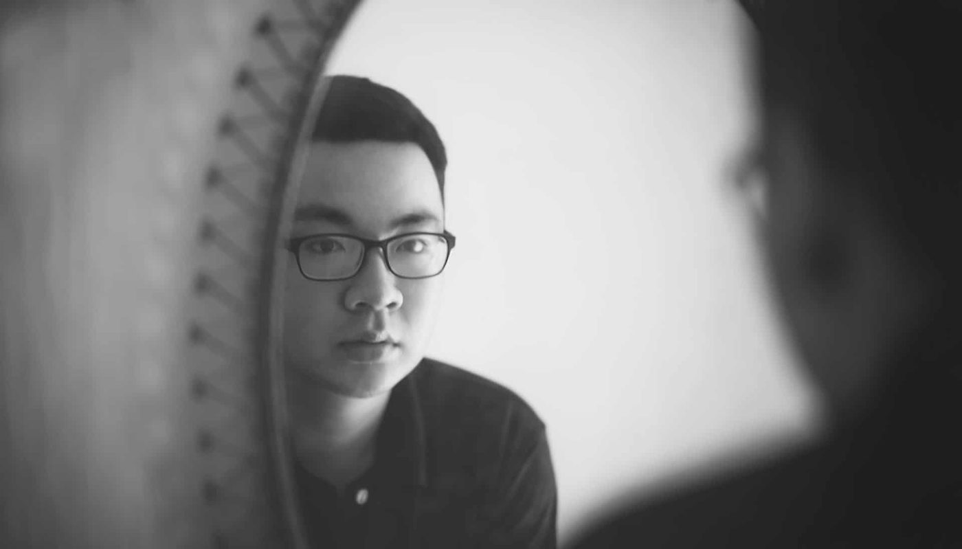 guy looking at himself in the mirror, contemplating