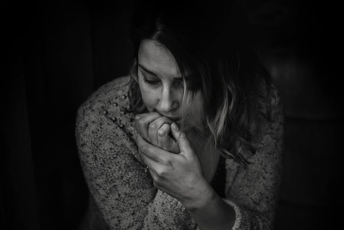 anxious woman sitting and biting her fingernails