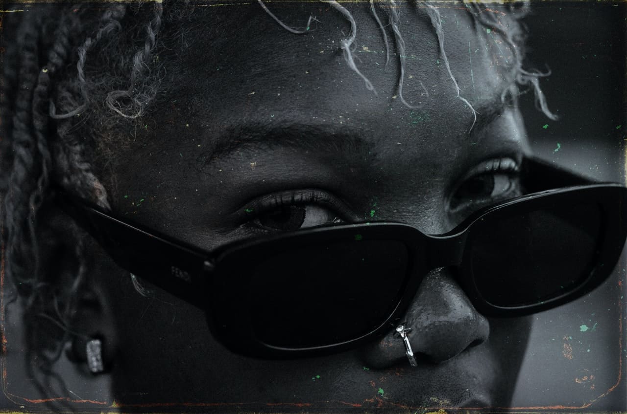 woman wearing sunglasses with eyes peaking above with a powerful stare