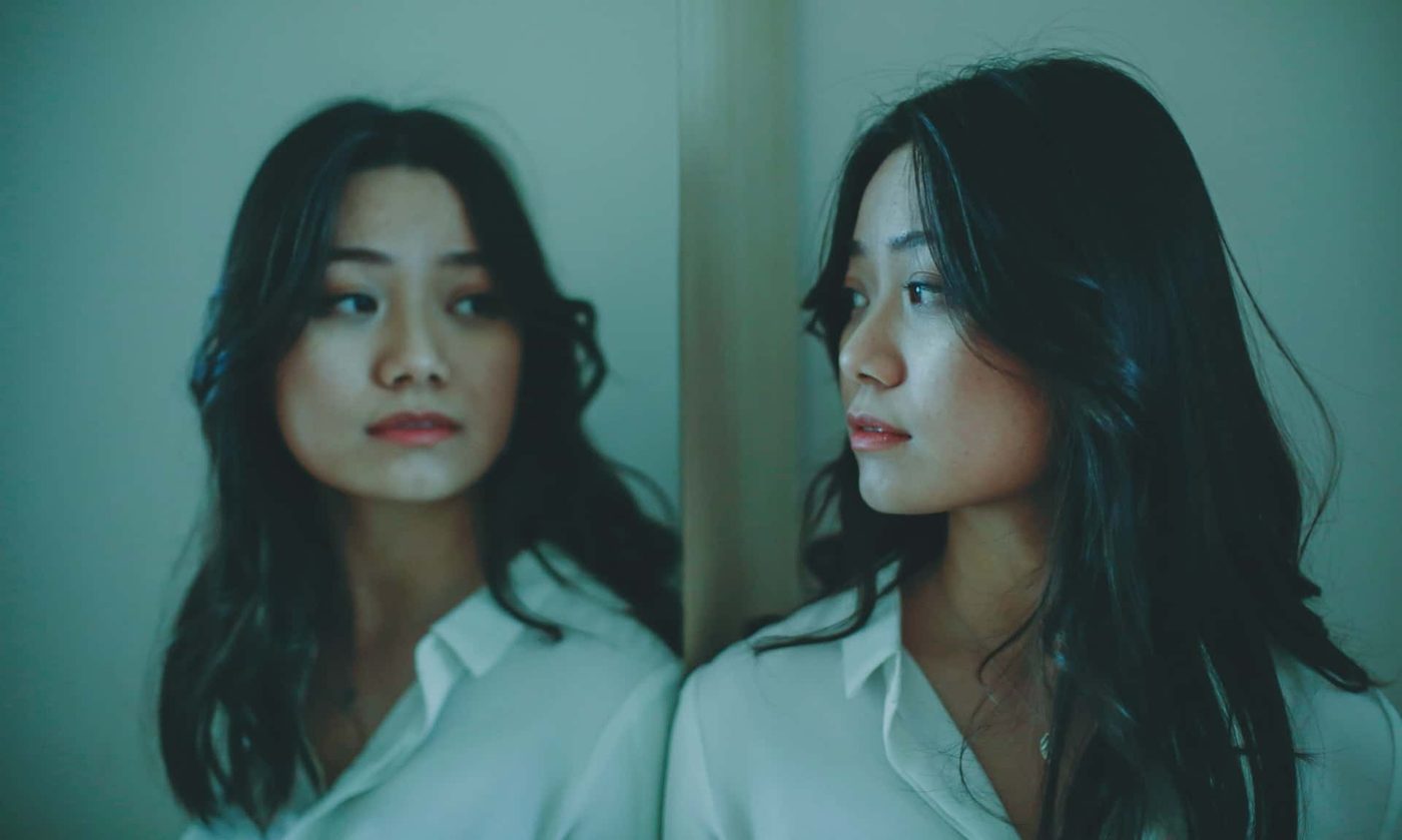 woman looking at herself in the mirror with a look of hope