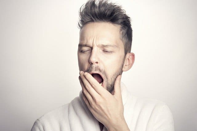 guy yawning with his hand covering his mouth