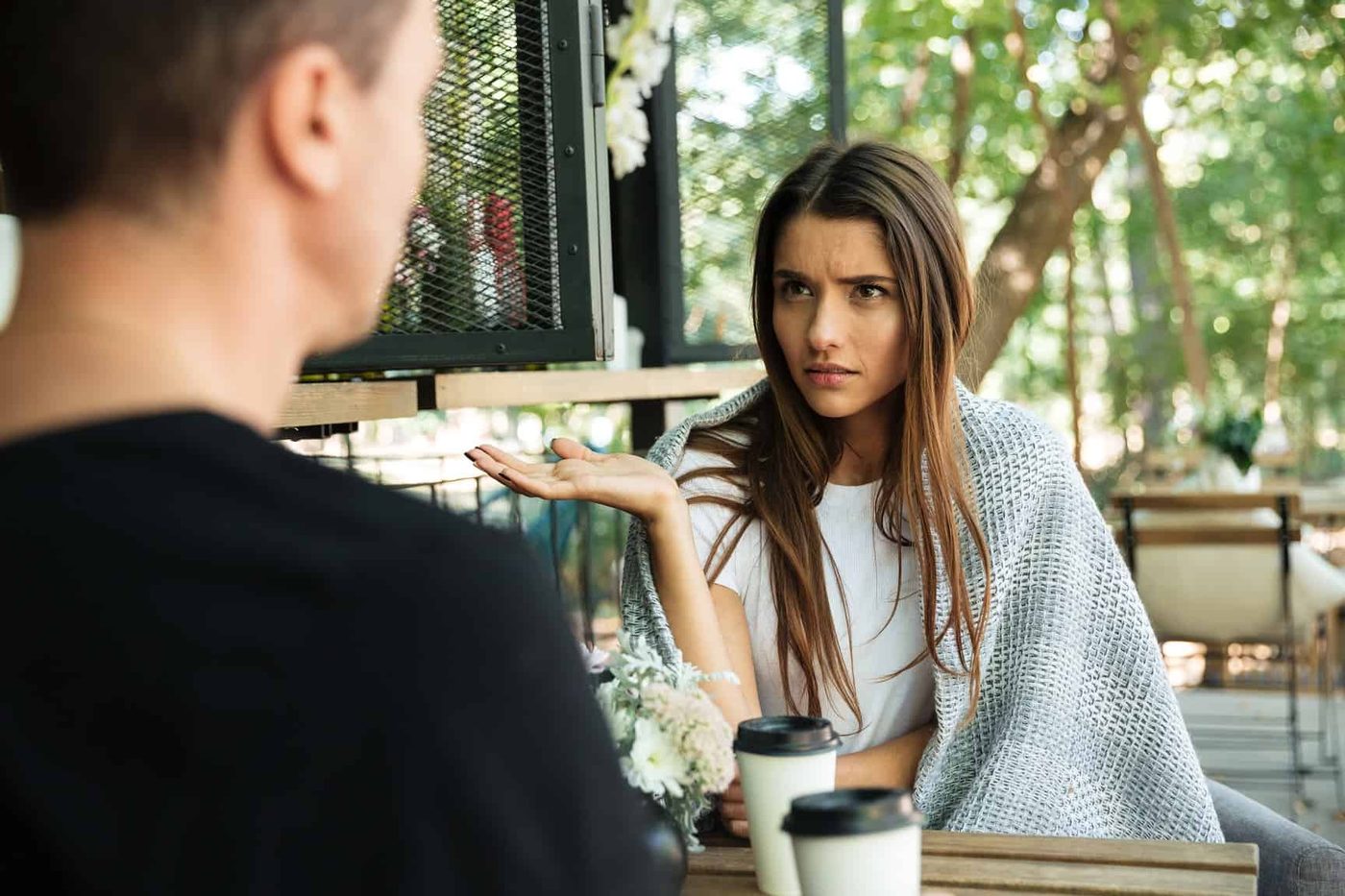 confused woman sitting man back