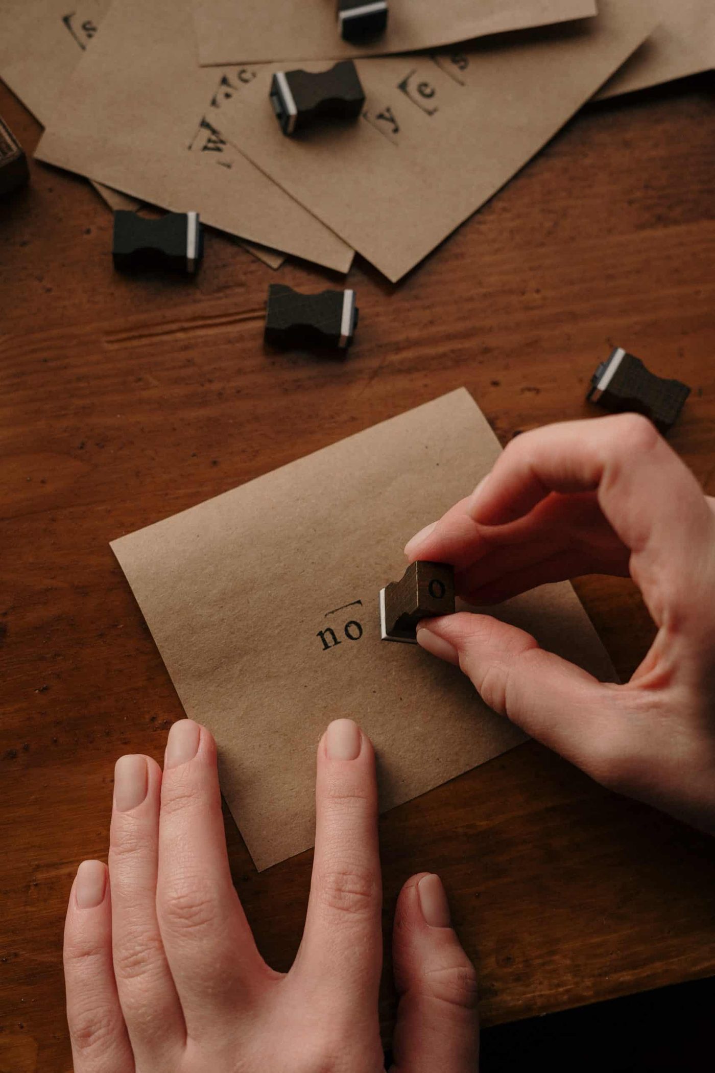 person holding piece of paper stamping the word 'no' on it