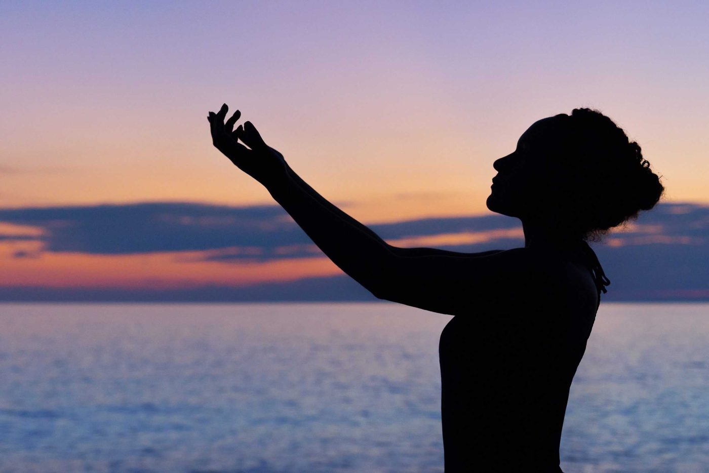 silhouette of a woman at the beach on twilight