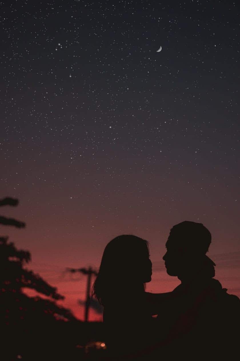 silhouette of couple at sunset holding each other