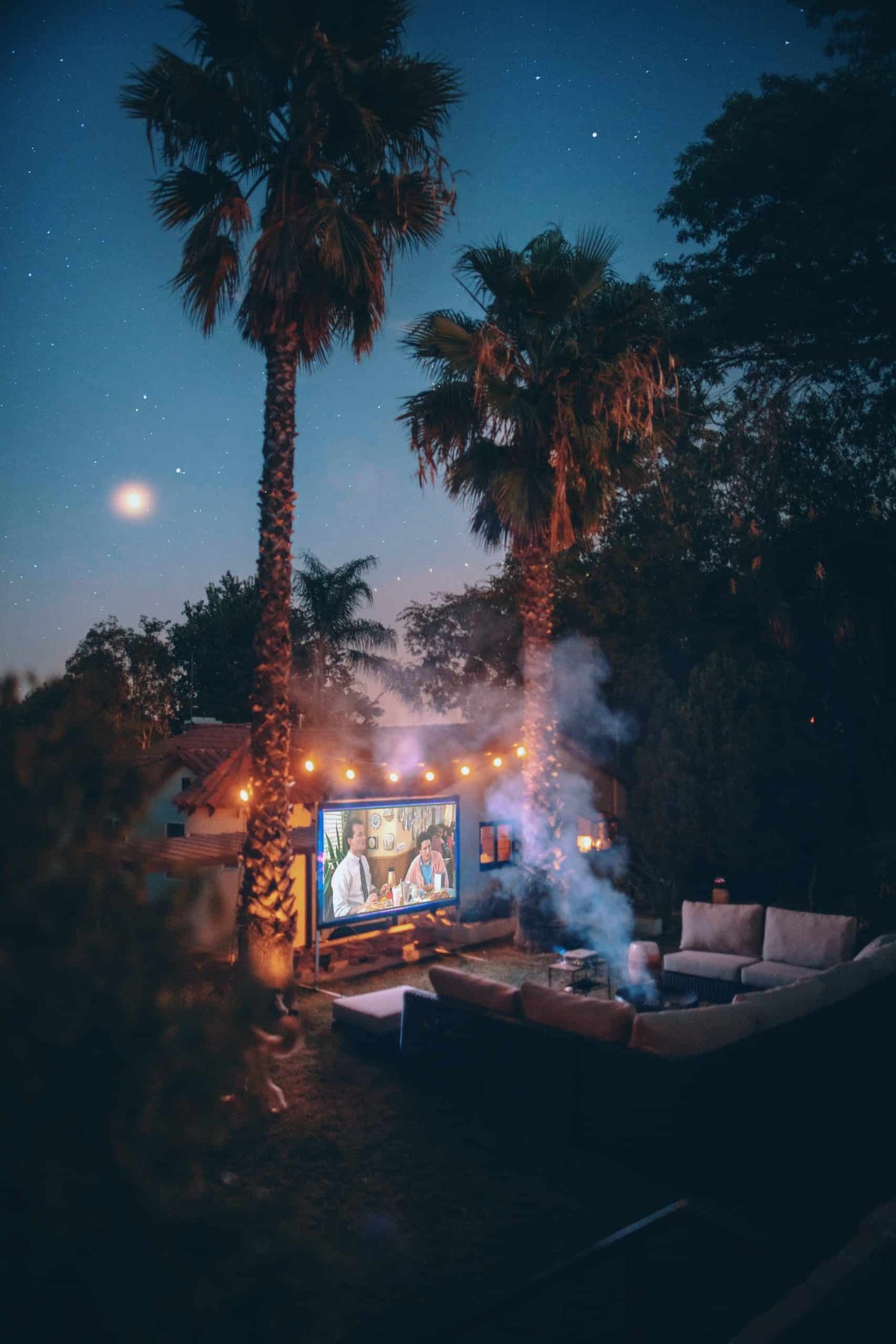 back yard hangout sofa circle with a screen projector and a movie