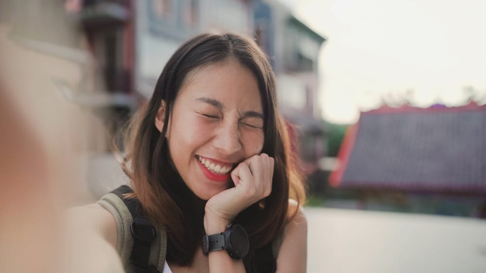 Cheerful beautiful young backpacker woman take selfie