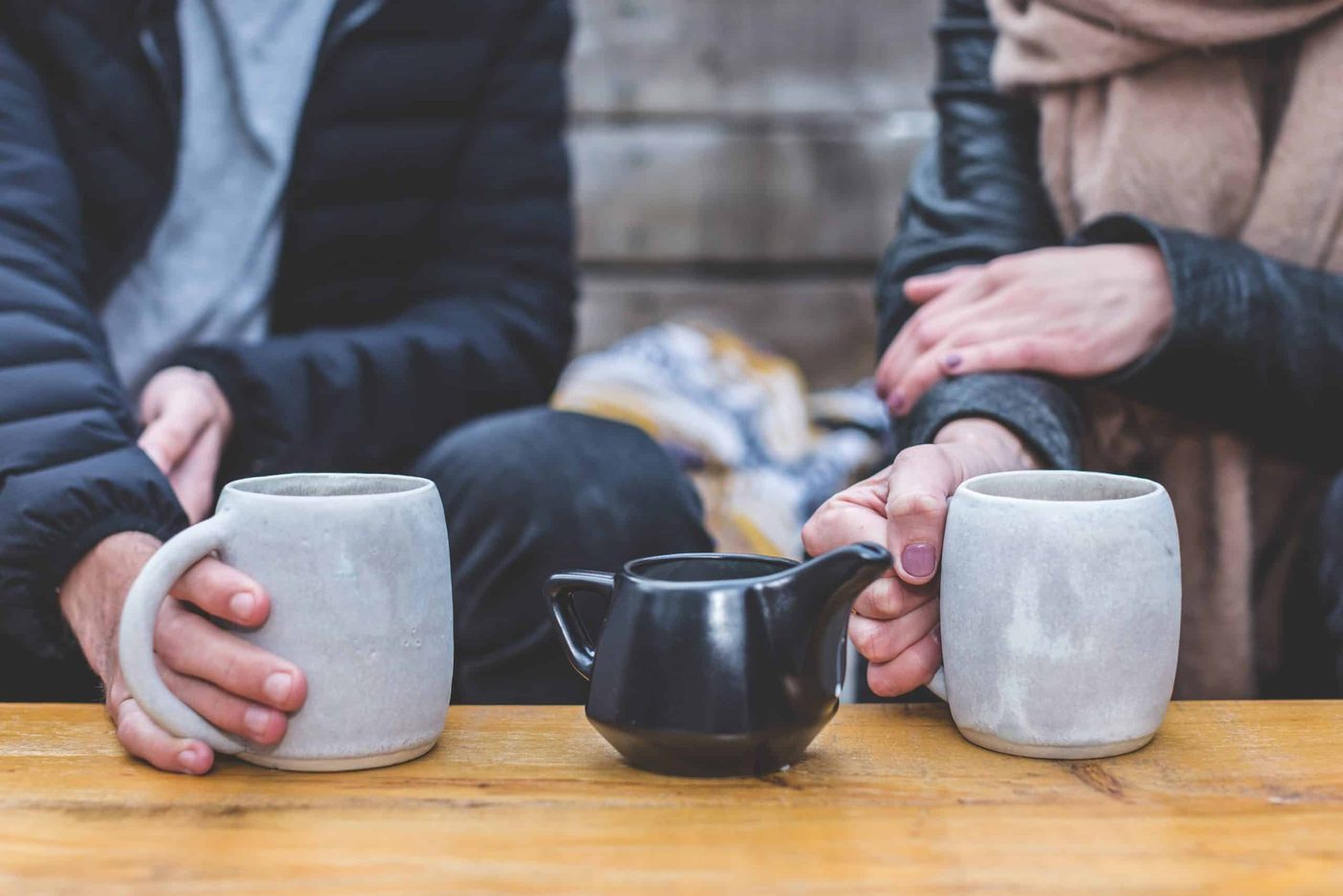 Man and woman drinking coffee together holding gray stone mugs