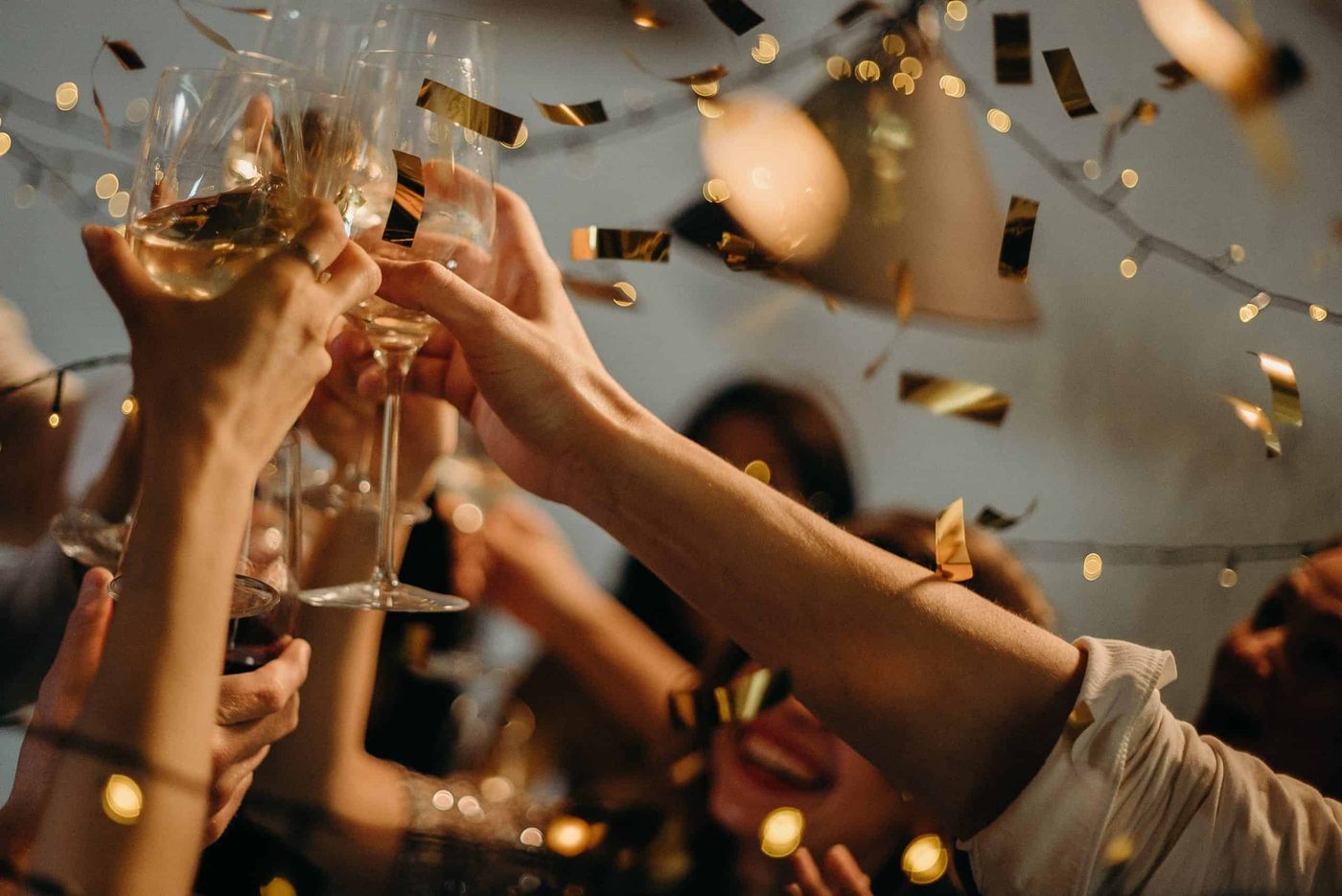 people cheering and clinking champagne glasses at office party